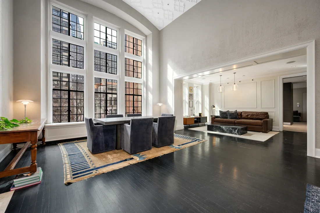 Double-height living room with tall windows, a sculptural ceiling and charcoal floors