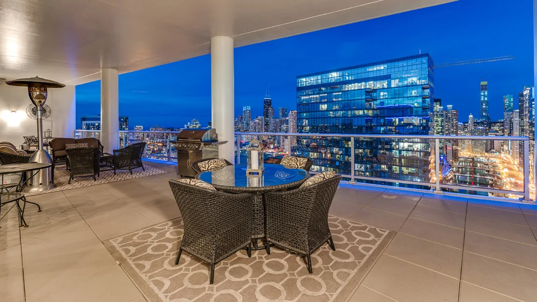 Chicago skyline at blue hour beyond a warmly lit dining room
